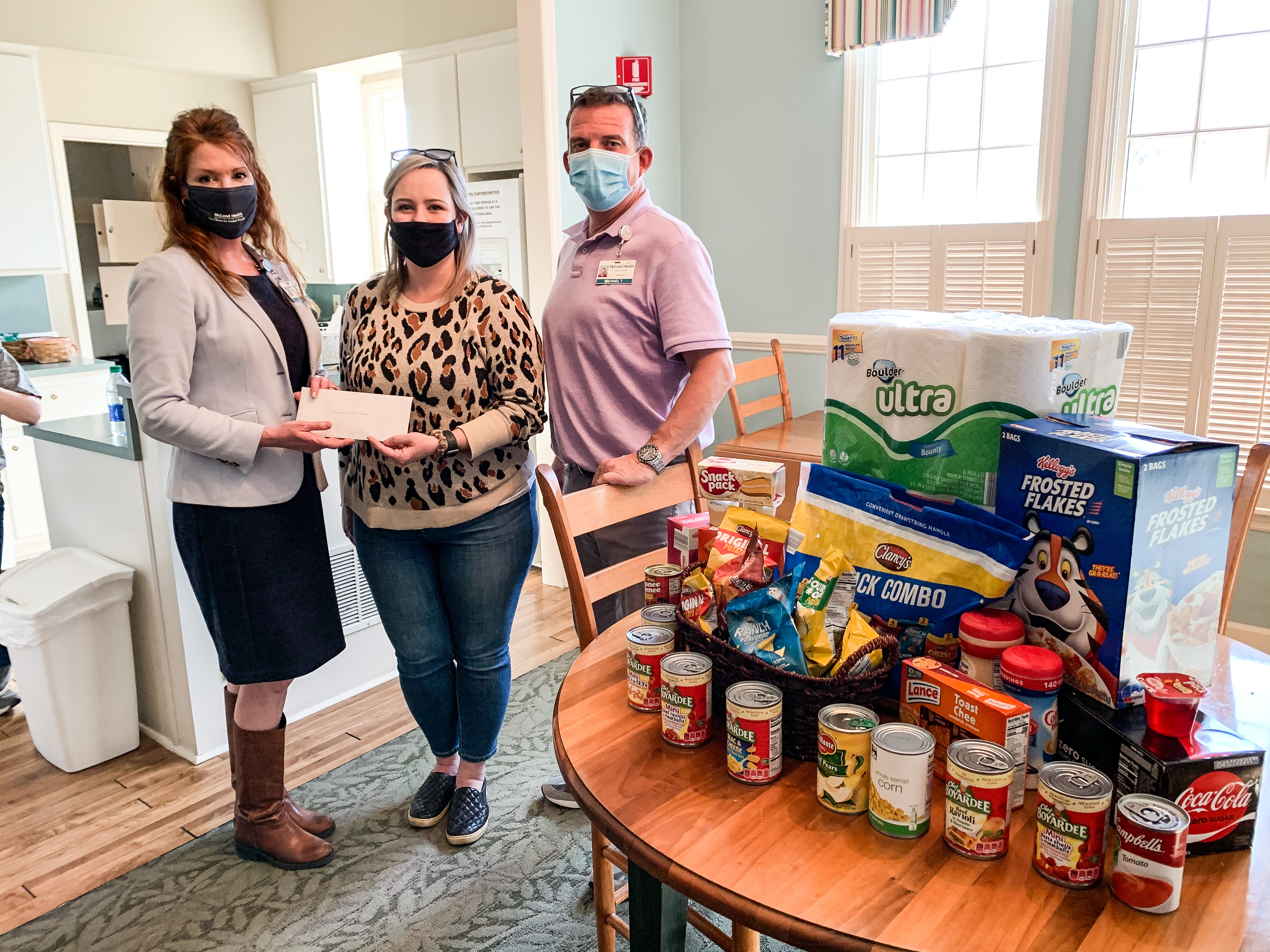 Donors pose with check and donated food