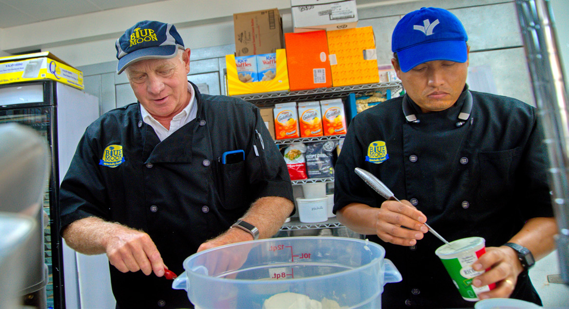 Chefs adding ingredients to containers