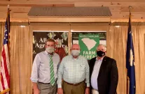 Masked men posing by SC and US flags