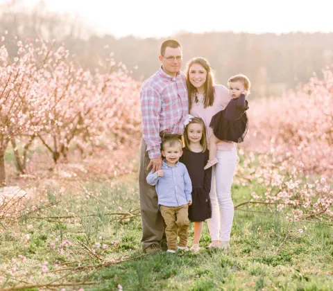 Family posing in an orchard